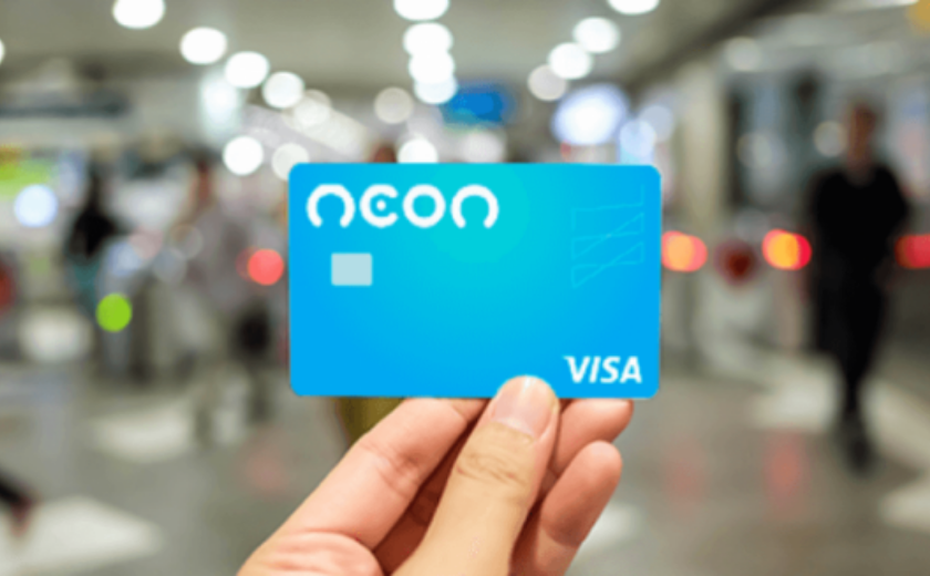 uma mao segurando o cartao neon visa internacional